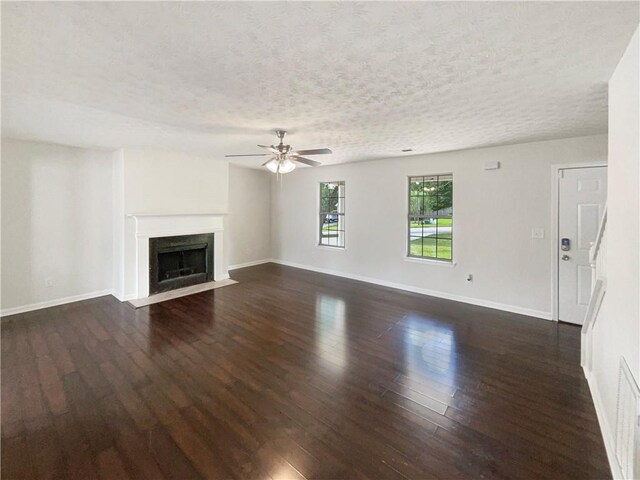727 Overlook Crst, Monroe, GA 30655 - unfurnished living room with ceiling fan, baseboards, a textured ceiling, dark wood finished floors, and a fireplace with flush hearth