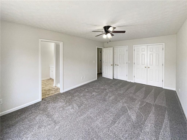 727 Overlook Crst, Monroe, GA 30655 - unfurnished bedroom featuring dark carpet, multiple closets, baseboards, and a ceiling fan