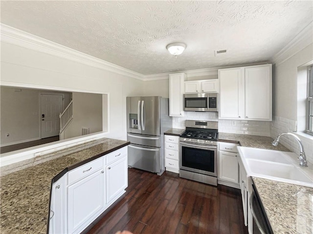 727 Overlook Crst, Monroe, GA 30655 - kitchen with stainless steel appliances, a sink, dark wood-style floors, white cabinets, and crown molding