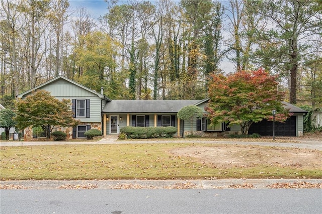 split level home featuring stone siding and a front yard