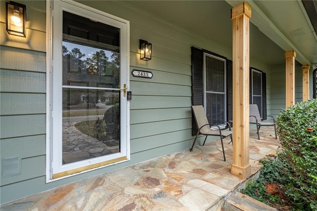 entrance to property featuring visible vents and covered porch