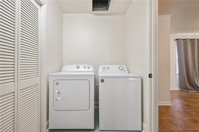 washroom featuring laundry area, dark tile patterned floors, washing machine and dryer, and baseboards