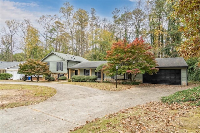 tri-level home featuring curved driveway and a garage