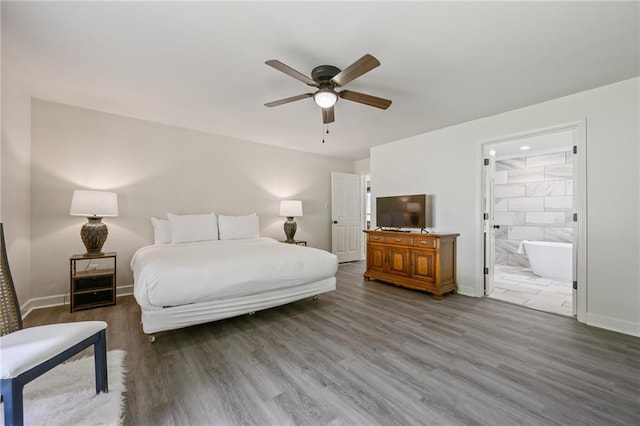 bedroom with connected bathroom, a ceiling fan, baseboards, and wood finished floors