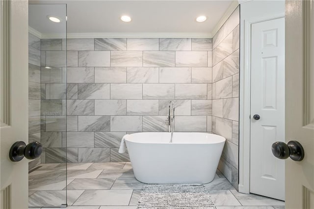 full bath with a freestanding tub, a walk in shower, marble finish floor, and ornamental molding