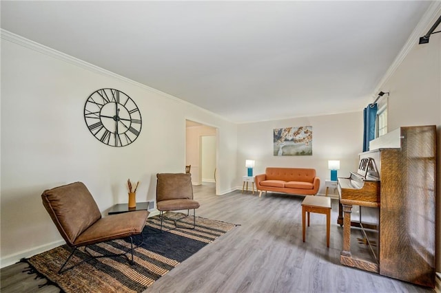 living area with ornamental molding, baseboards, and wood finished floors