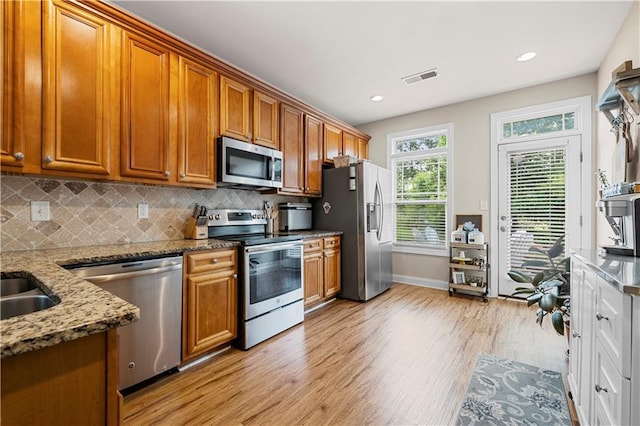 240 Daisy Cir, Mcdonough, GA 30252 - kitchen with appliances with stainless steel finishes, light wood-style flooring, brown cabinetry, stone counters, and recessed lighting