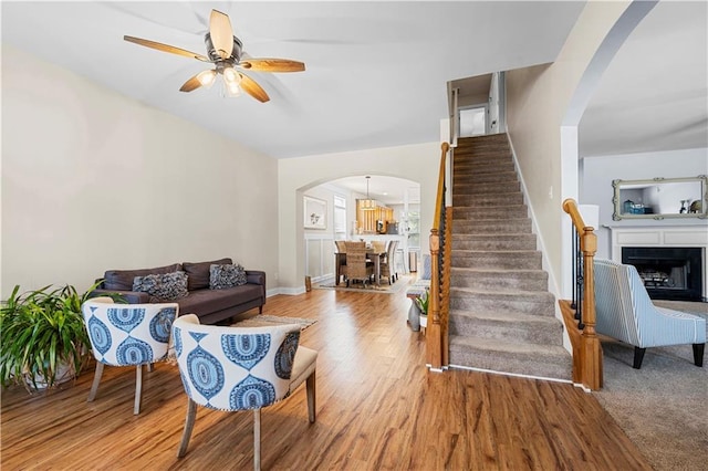 240 Daisy Cir, Mcdonough, GA 30252 - living area with arched walkways, stairway, a ceiling fan, wood finished floors, and a fireplace