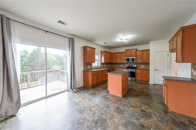 5280 Lakerock Way S, Fulton, GA 30331 - kitchen featuring stainless steel appliances, tasteful backsplash, a center island, and brown cabinets