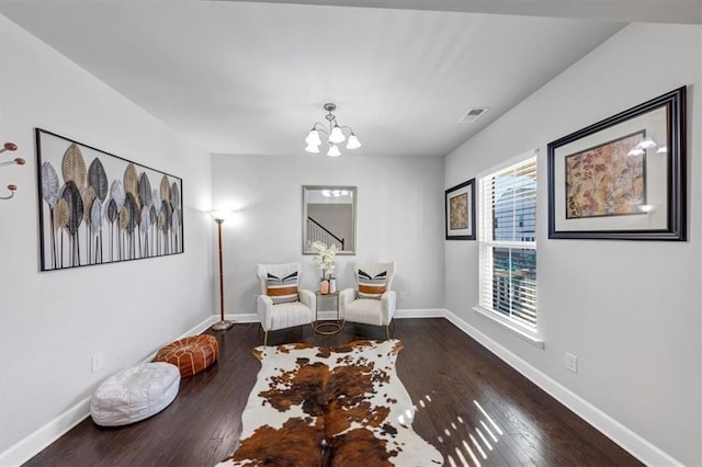 sitting room featuring dark hardwood / wood-style floors and a chandelier