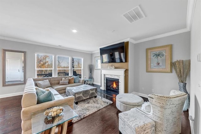 living room featuring a stone fireplace, crown molding, and dark wood-type flooring