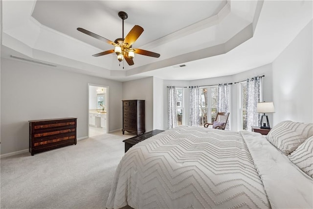 bedroom with baseboards, visible vents, ensuite bath, a tray ceiling, and carpet flooring