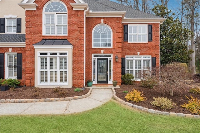 traditional-style home with brick siding and roof with shingles