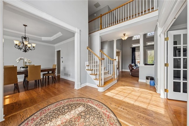 entrance foyer featuring ornamental molding, stairway, wood finished floors, and visible vents