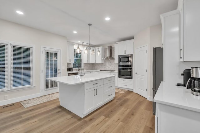 1547 Trilogy Park, Hoschton, GA 30548 - kitchen featuring stainless steel appliances, wall chimney exhaust hood, light countertops, white cabinets, and decorative backsplash