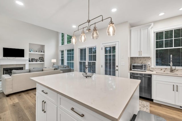 1547 Trilogy Park, Hoschton, GA 30548 - kitchen featuring dishwasher, a sink, light wood-style flooring, backsplash, and a kitchen island