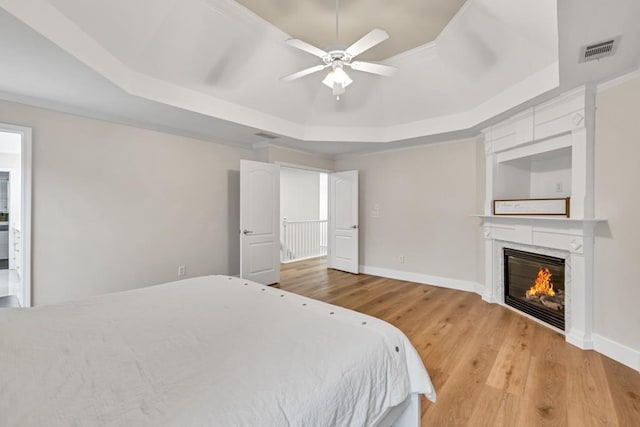 1547 Trilogy Park, Hoschton, GA 30548 - bedroom featuring a raised ceiling, light wood-style flooring, a high end fireplace, baseboards, and ceiling fan