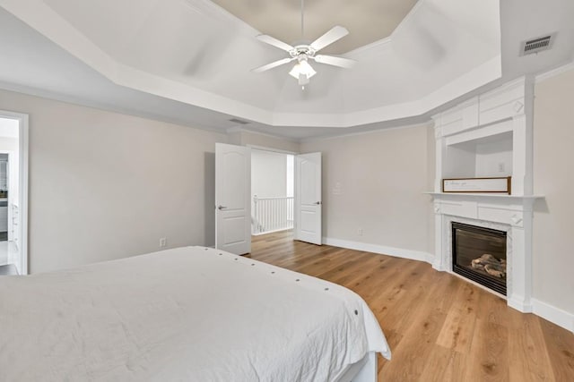 1547 Trilogy Park, Hoschton, GA 30548 - bedroom with a raised ceiling, light wood finished floors, a fireplace, baseboards, and a ceiling fan
