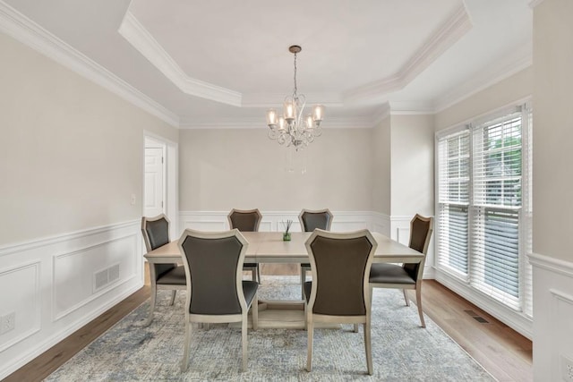1547 Trilogy Park, Hoschton, GA 30548 - dining room with a tray ceiling, a chandelier, ornamental molding, wood finished floors, and a wainscoted wall