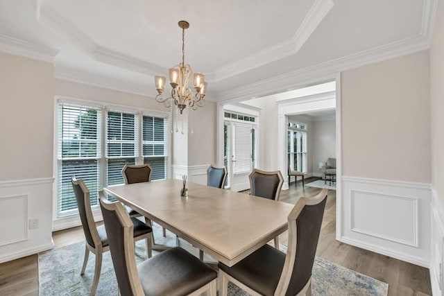 1547 Trilogy Park, Hoschton, GA 30548 - dining area featuring a chandelier, a raised ceiling, a wainscoted wall, wood finished floors, and crown molding