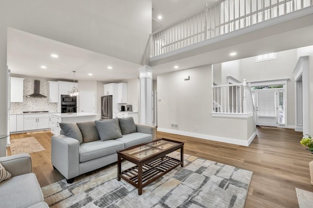 1547 Trilogy Park, Hoschton, GA 30548 - living area with a high ceiling, light wood finished floors, baseboards, recessed lighting, and stairs