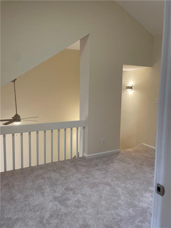 carpeted spare room with a ceiling fan and high vaulted ceiling