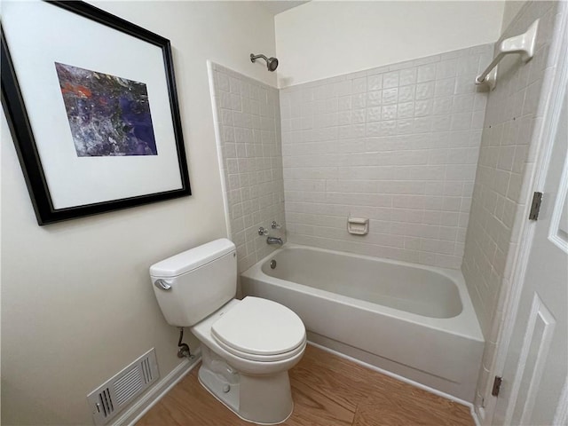 bathroom with visible vents, shower / tub combination, wood finished floors, and toilet