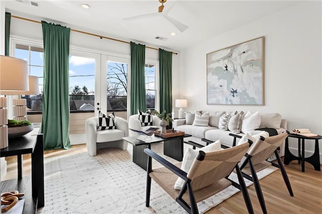 living room featuring ceiling fan, french doors, and light hardwood / wood-style floors