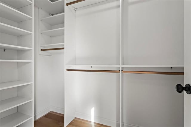 walk in closet with hardwood / wood-style flooring