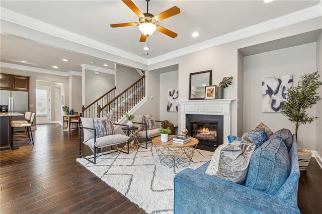 living room featuring dark wood-type flooring, ceiling fan, and crown molding