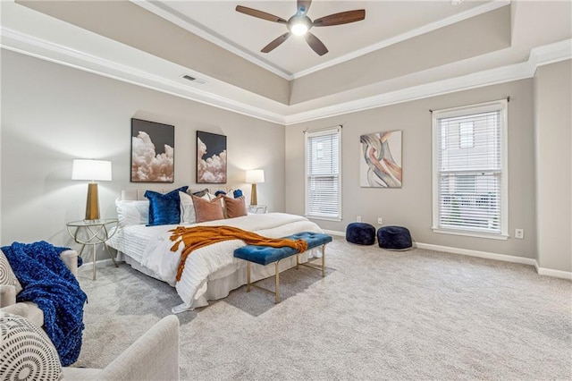 carpeted bedroom featuring crown molding, a raised ceiling, visible vents, ceiling fan, and baseboards