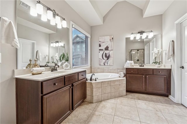 bathroom with lofted ceiling, a garden tub, a sink, a shower stall, and tile patterned floors