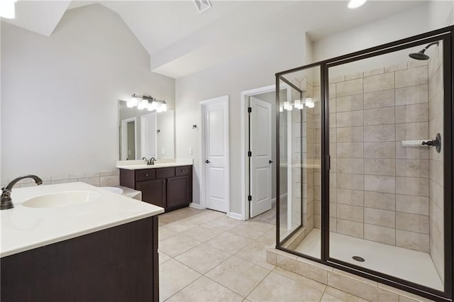 full bath with lofted ceiling, a stall shower, a sink, and tile patterned floors