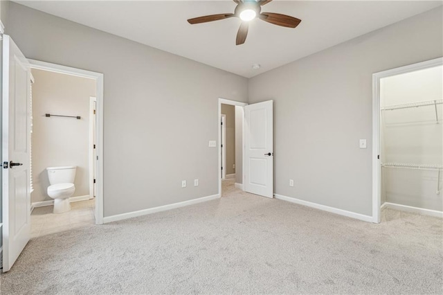 unfurnished bedroom with a spacious closet, baseboards, and carpet flooring