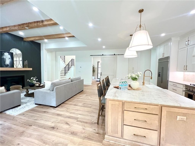 356 Henry Scott Rd, Ball Ground, GA 30107 - kitchen featuring high quality fridge, a sink, a barn door, open floor plan, and light wood finished floors