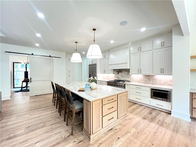 356 Henry Scott Rd, Ball Ground, GA 30107 - kitchen featuring a barn door, high end stainless steel range oven, custom exhaust hood, decorative backsplash, and a kitchen bar