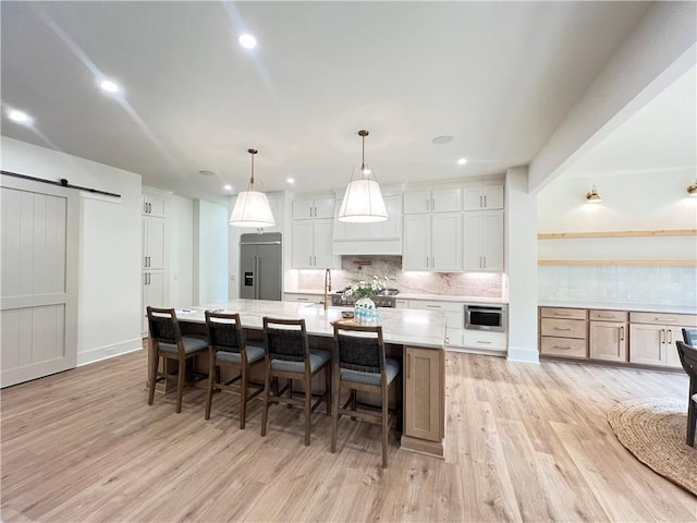 356 Henry Scott Rd, Ball Ground, GA 30107 - kitchen with high end refrigerator, tasteful backsplash, a barn door, light wood-type flooring, and recessed lighting