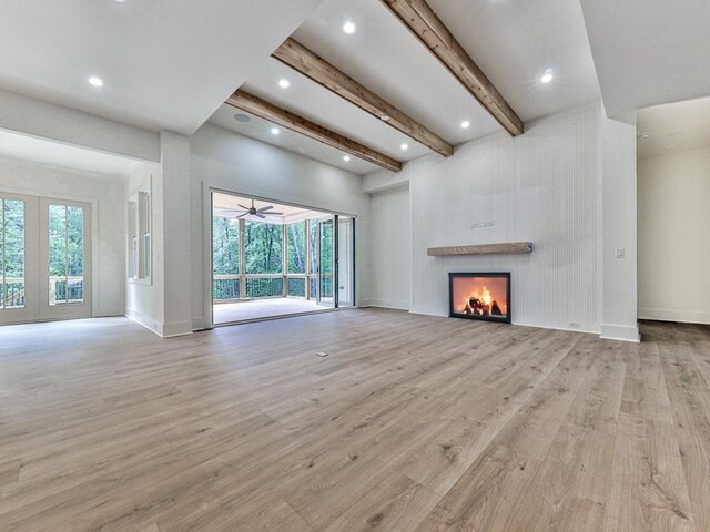 356 Henry Scott Rd, Ball Ground, GA 30107 - unfurnished living room with wood finished floors, plenty of natural light, a lit fireplace, beam ceiling, and baseboards
