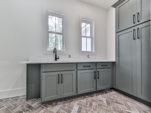 356 Henry Scott Rd, Ball Ground, GA 30107 - kitchen with gray cabinetry, brick patterned flooring, a sink, and light countertops