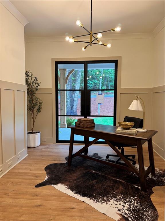 356 Henry Scott Rd, Ball Ground, GA 30107 - home office featuring a decorative wall, ornamental molding, a chandelier, light wood-type flooring, and wainscoting