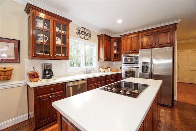 kitchen featuring sink, a center island, dark hardwood / wood-style floors, appliances with stainless steel finishes, and ornamental molding