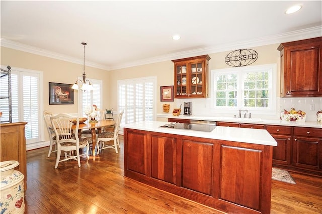 kitchen featuring sink, dark hardwood / wood-style floors, a notable chandelier, crown molding, and decorative light fixtures