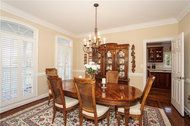 dining room with a chandelier, dark wood-type flooring, and ornamental molding