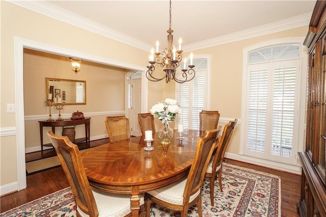 dining space with ornamental molding, dark wood-type flooring, and an inviting chandelier