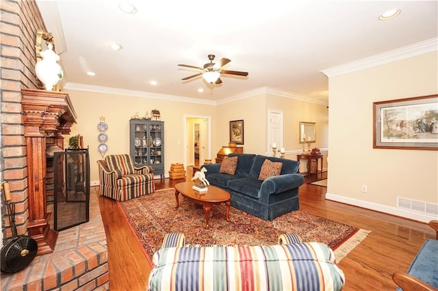 living room with a fireplace, ceiling fan, wood-type flooring, and crown molding