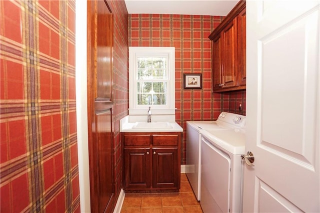 laundry area featuring cabinets, light tile patterned floors, washing machine and dryer, and sink