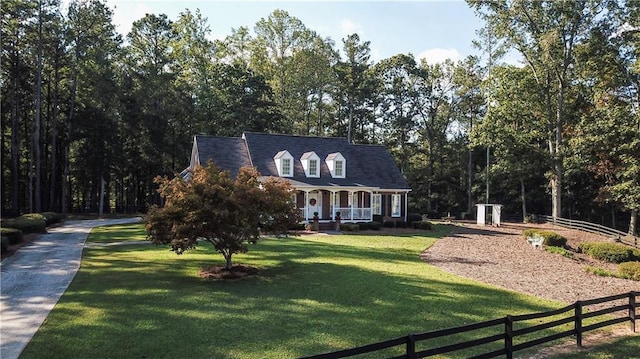 cape cod home with a front yard and covered porch