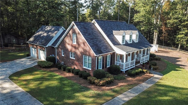 view of front facade featuring a front lawn, covered porch, and a garage