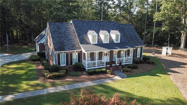 cape cod house featuring a front lawn and a porch