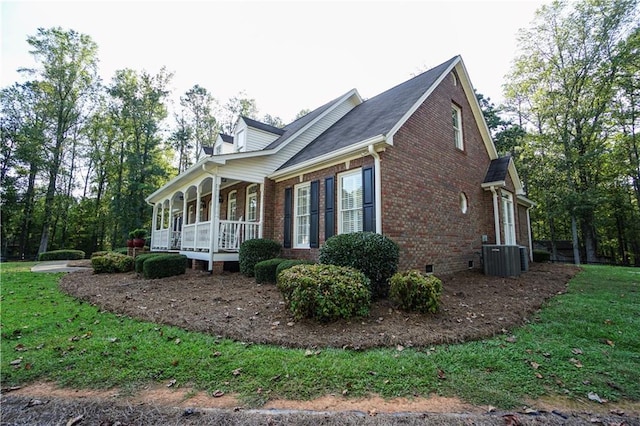 view of home's exterior featuring central air condition unit, a yard, and covered porch